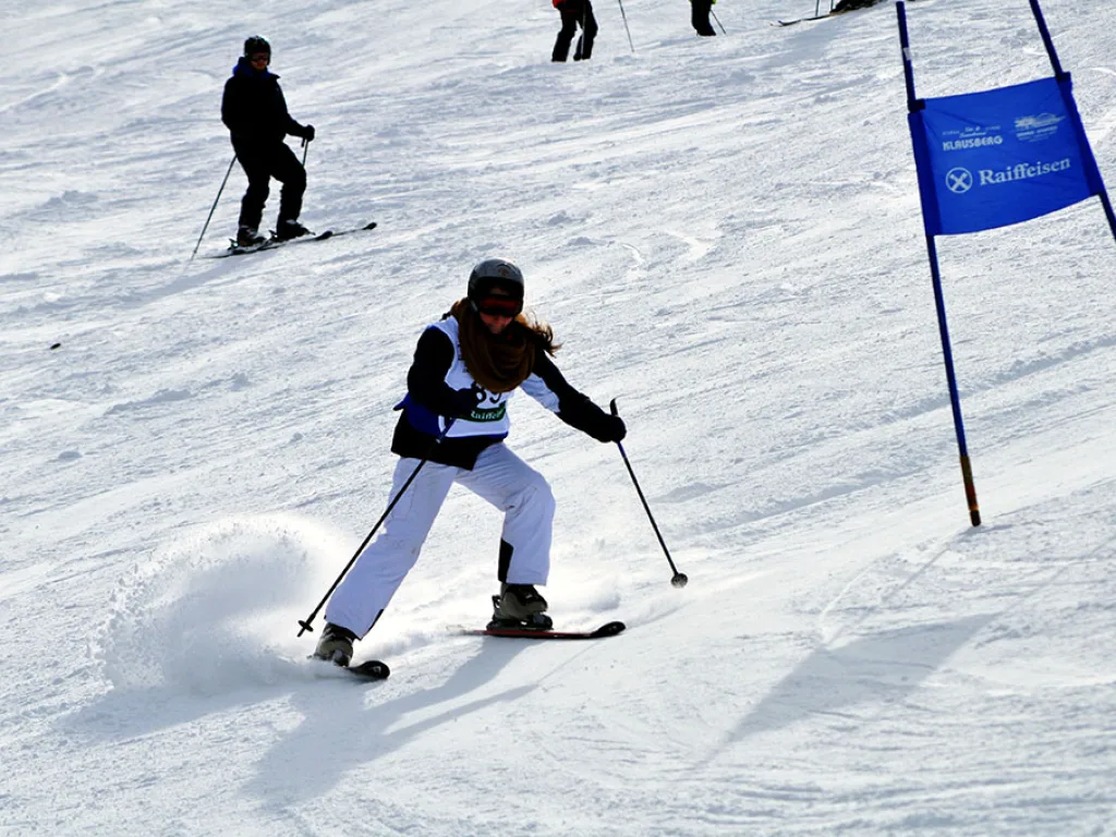 Skifahrerin in weißer Hose auf der Rennstrecke.